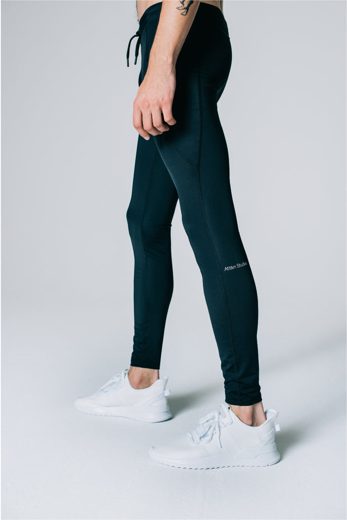 Sustainable Performance Tights in black for men. Detail of reflecting logoprint.